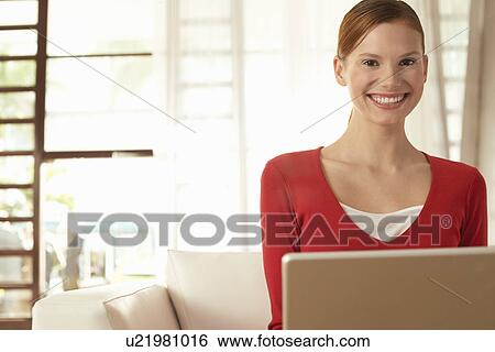 Young woman using laptop at home portrait View Large Photo Image Stock Photograph - Young woman using laptop at home portrait. Fotosearch