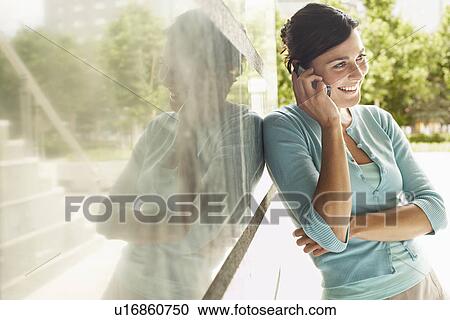 Stock Image - Young woman using mobile phone.. Fotosearch