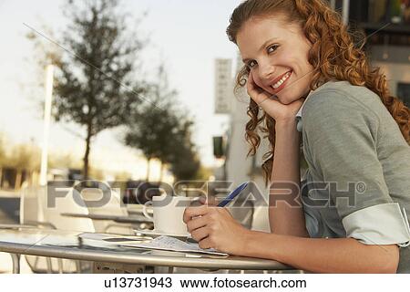 Young woman writing at outdoor cafe portrait View Large Photo Image Stock Image - Young woman writing at outdoor cafe portrait. Fotosearch
