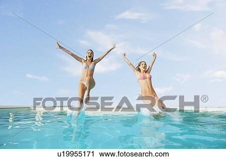 Young Women Jumping into Swimming Pool front view View Large Photo Image Stock Image - Young Women Jumping into Swimming Pool front view. Fotosearch