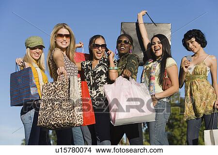Picture - Young women with shopping bags outdoors (portrait). Fotosearch