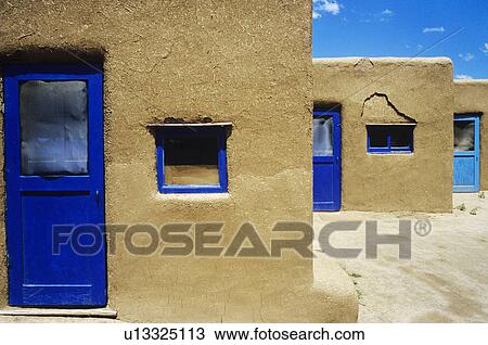 Stock Image - Adobe houses with blue windows and door frames. Fotosearch