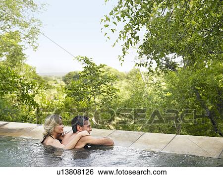 Adult couple in pool looking at view back view View Large Photo Image Stock Photograph - Adult couple in pool looking at view back view. Fotosearch