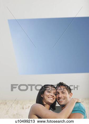 Stock Image - Affectionate Young Couple Under Skylight. Fotosearch