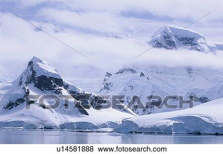 Stock Photo - Antarctica Snow covered mountains and icebergs. Fotosearch