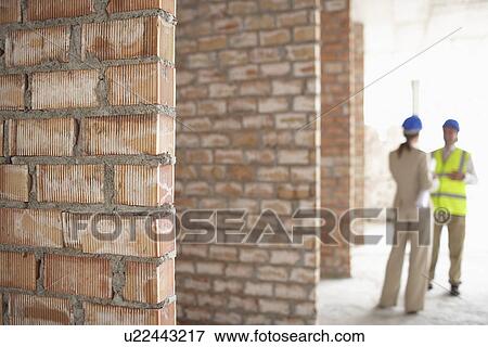 Stock Photo - Architect and construction manager on site focus on foreground. Fotosearch