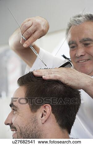 Barber cutting mans hair in barber shop close-up View Large Photo Image Stock Image - Barber cutting mans hair in barber shop close-up. Fotosearch