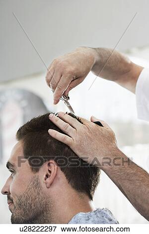 Barber cutting mans hair in barber shop View Large Photo Image Stock Photo - Barber cutting mans hair in barber shop. Fotosearch