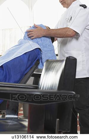 Picture - Barber drying mans hair in barber shop. Fotosearch