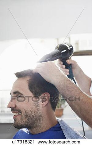 Barber drying mans hair in barber shop View Large Photo Image Stock Image - Barber drying mans hair in barber shop. Fotosearch