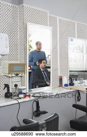 Barber preparing business man for haircut in barber shop View Large Photo Image Stock Image - Barber preparing business man for haircut in barber shop. Fotosearch