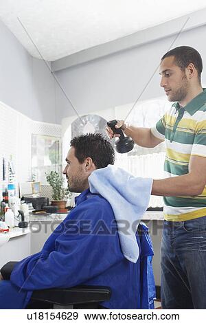 Barber preparing man for haircut in barber shop View Large Photo Image Stock Photo - Barber preparing man for haircut in barber shop. Fotosearch