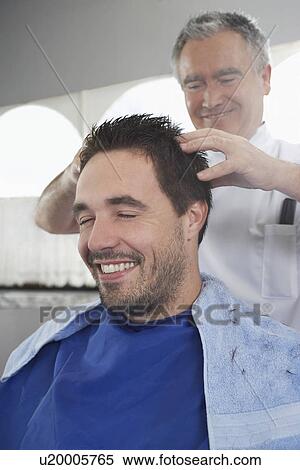 Barber preparing man for haircut in barber shop View Large Photo Image Stock Photography - Barber preparing man for haircut in barber shop. Fotosearch