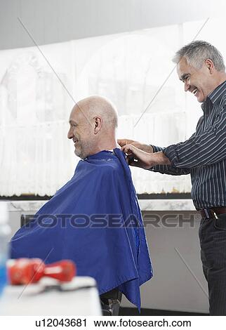 Barber removing cape from man in barber shop View Large Photo Image Stock Image - Barber removing cape from man in barber shop. Fotosearch