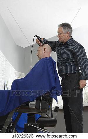 Barber shaving mans head in barber shop View Large Photo Image Stock Image - Barber shaving mans head in barber shop. Fotosearch
