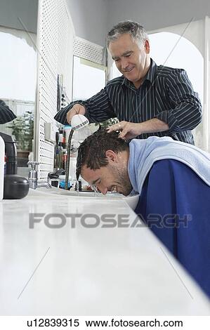 Stock Photography - Barber washing mans head in barber shop. Fotosearch