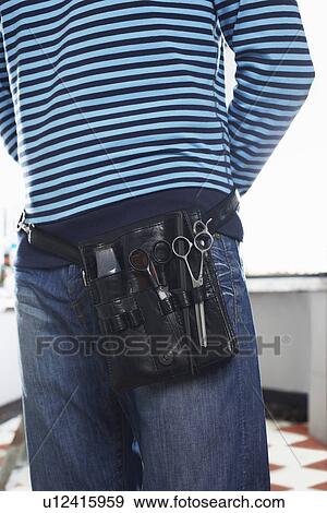 Stock Photo - Barber with scissors in belt mid section. Fotosearch