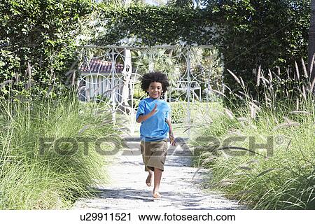 Stock Image - Boy (5-6 years) running on path. Fotosearch