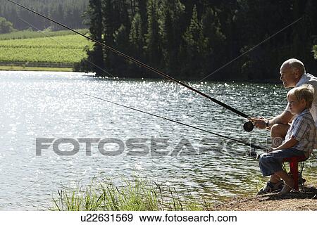 Boy (7-9) fishing with grandfather side view. View Large Photo Image Stock Photo - Boy (7-9) fishing with grandfather side view.. Fotosearch