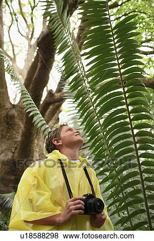 Stock Photo - Boy Taking Photos in Forest. Fotosearch