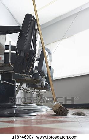 Stock Photo - Broom beside barbers chairs. Fotosearch