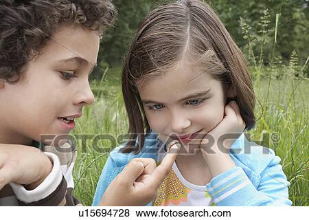 Brother and sister (7-9) examining caterpillar in field View Large Photo Image Stock Photo - Brother and sister (7-9) examining caterpillar in field. Fotosearch