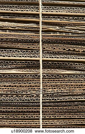 Stock Photo - Bundle of corrugated cardboard tied with string close-up full frame. Fotosearch