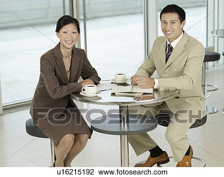 Stock Image - Business colleagues Sitting at table portrait. Fotosearch