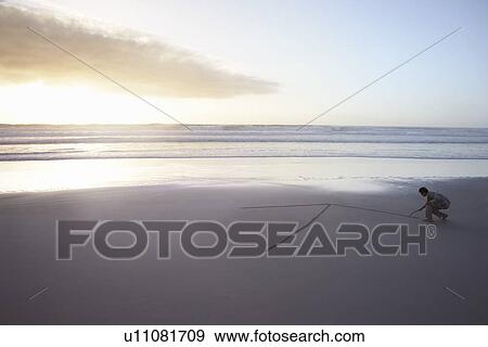 Business man drawing arrow in sand on beach elevated view View Large Photo Image Stock Photo - Business man drawing arrow in sand on beach elevated view. Fotosearch