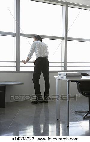 Business man looking out of office window back view View Large Photo Image Stock Photo - Business man looking out of office window back view. Fotosearch