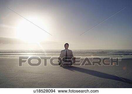 Business man sitting in lotus pose on beach View Large Photo Image Picture - Business man sitting in lotus pose on beach. Fotosearch