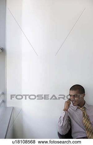 Stock Photo - Business man using mobile phone in office elevated view. Fotosearch