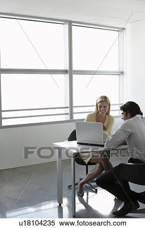 Business people using laptop sitting at office desk View Large Photo Image Stock Photography - Business people using laptop sitting at office desk. Fotosearch
