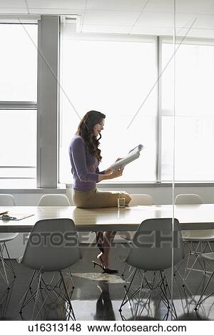 Stock Photo - Business woman sitting on conference table side view. Fotosearch