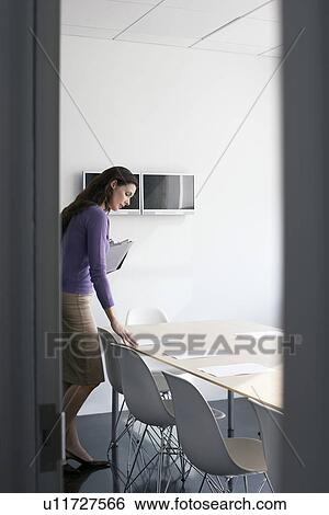 Stock Photograph - Business woman standing in conference room side view. Fotosearch