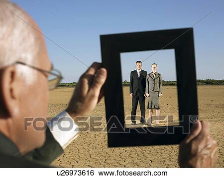 Businessman framing couple in desert View Large Photo Image Stock Photograph - Businessman framing couple in desert. Fotosearch