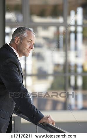 Stock Image - Businessman Leaning on Railing.. Fotosearch