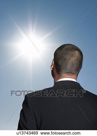 Businessman looking at sun head and shoulders back view View Large Photo Image Stock Photo - Businessman looking at sun head and shoulders back view. Fotosearch
