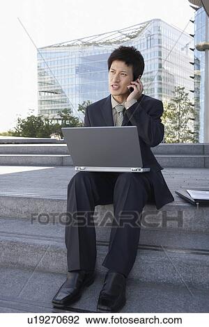 Businessman on outdoor Steps Using Laptop and talking on mobile View Large Photo Image Stock Image - Businessman on outdoor Steps Using Laptop and talking on mobile. Fotosearch