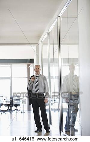 Stock Photograph - Businessman standing in Corridor portrait.. Fotosearch