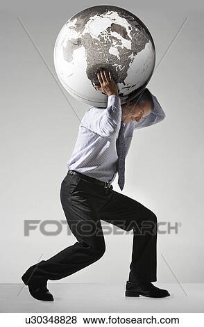 Stock Photo - Businessman struggling carrying globe on shoulders side view. Fotosearch