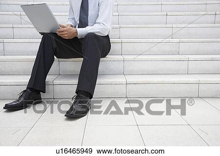 Businessman using laptop on steps outdoors low section View Large Photo Image Stock Photo - Businessman using laptop on steps outdoors low section. Fotosearch