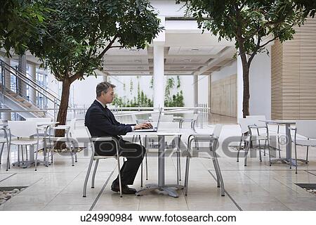 Picture - Businessman using laptop outdoors. Fotosearch