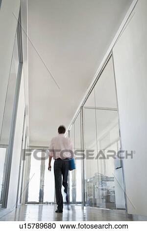 Businessman Walking in Corridor low angle back view. View Large Photo Image Stock Image - Businessman Walking in Corridor low angle back view.. Fotosearch