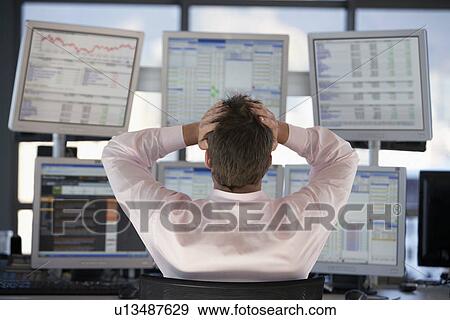Businessman watching computer screens with hands on head back view. View Large Photo Image Stock Photo - Businessman watching computer screens with hands on head back view.. Fotosearch