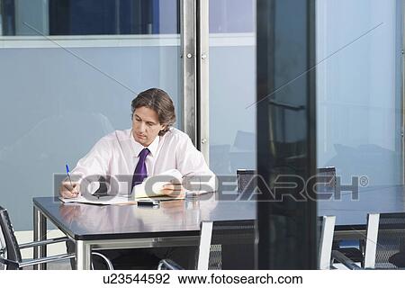 Stock Image - Businessman working in conference room. Fotosearch