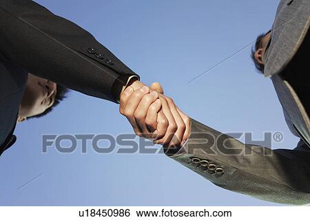 Stock Photograph - Businessmen Shaking Hands view from below. Fotosearch