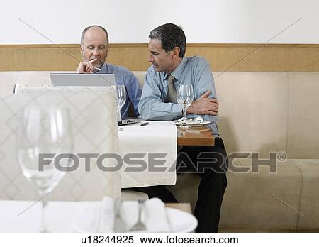 Businessmen using laptop in restaurant View Large Photo Image Stock Photography - Businessmen using laptop in restaurant. Fotosearch