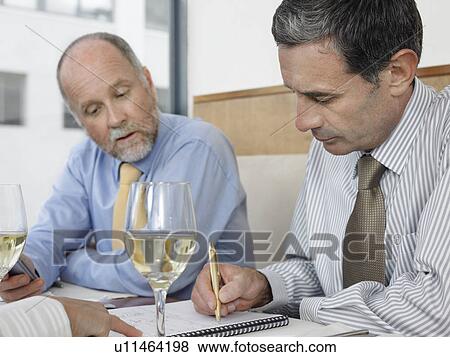 Stock Photo - Businessmen working in restaurant. Fotosearch