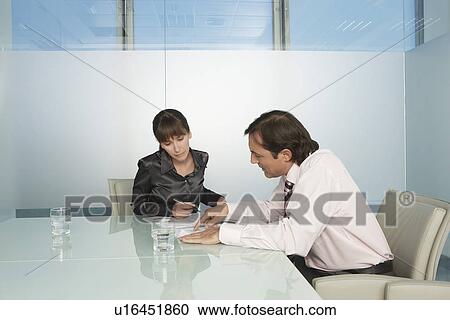 Stock Image - Businesspeople having meeting in office. Fotosearch